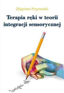 Zdjęcie okładki książki "Terapia ręki w teorii integracji sensorycznej". Na pierwszym planie widoczna ręka z ołówkiem i pisze.