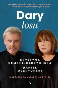 Zdjęcie okładki książki "Dary losu". W centralnej części twarze: Daniela Olbrychskiego i Krystyny Demskiej-Olbrychskiej. Nad nimi na ciemnym niebieskim tle tytuł książki.