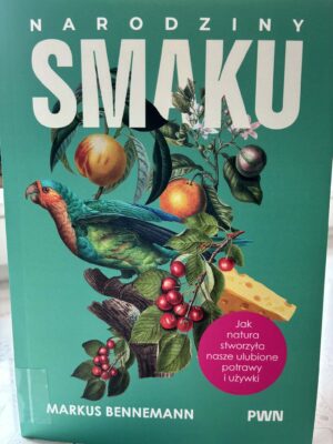 Zdjęcie okładki książki "Narodziny smaku". Zielone tło, na nim na pierwszym planie widoczna kolorowa papuga, zielone gałązki z owocami. U góry tytuł książki.