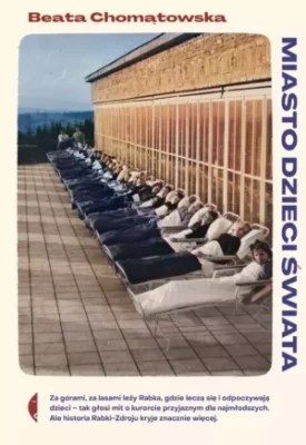 Zdjęcie okładki książki "Miasto dzieci świata". Pod ścianą budynku widać równo ułożone leżaki z leżącymi dzieci.
